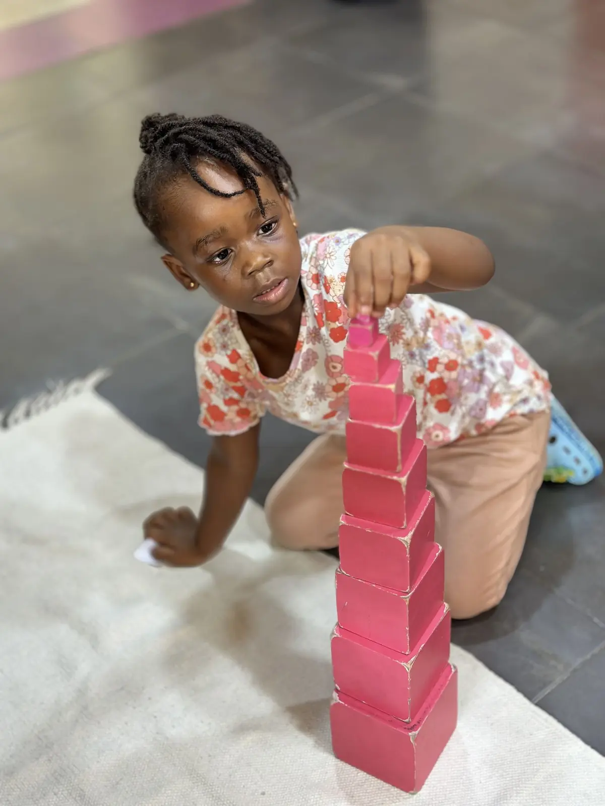 A child at Aquila Nidus working independently with the Montessori pink tower