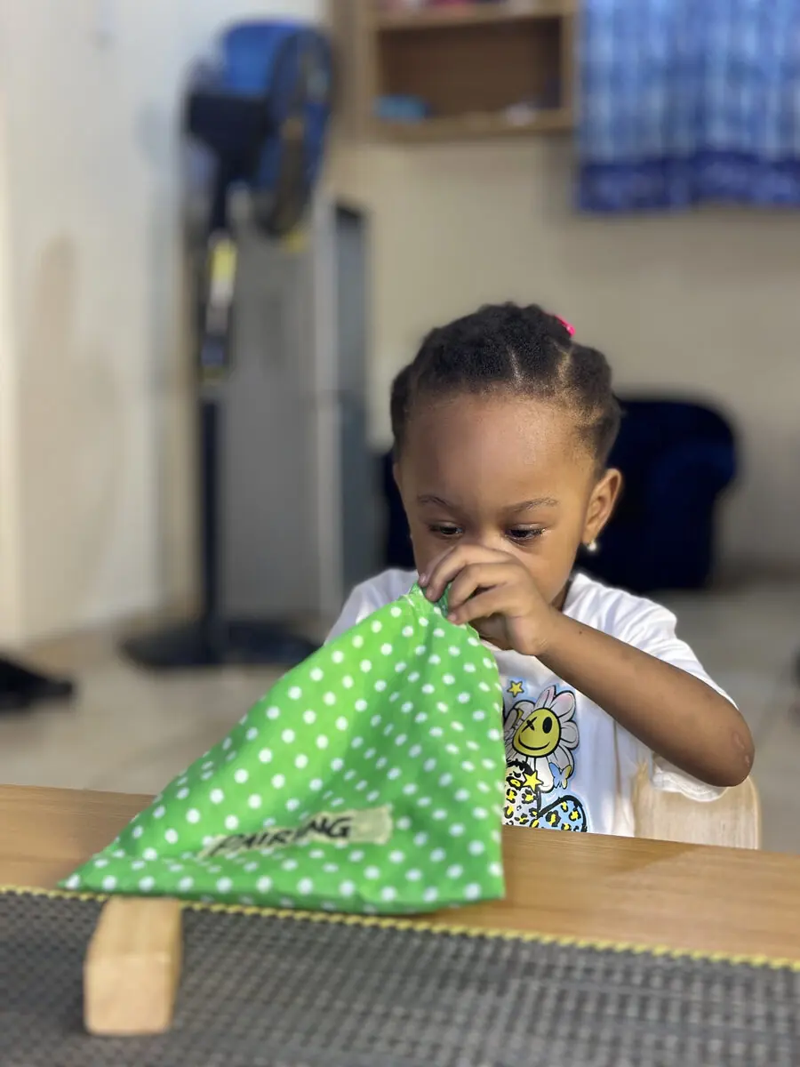 A Nido child exploring a fabric-pairing sensorial activity