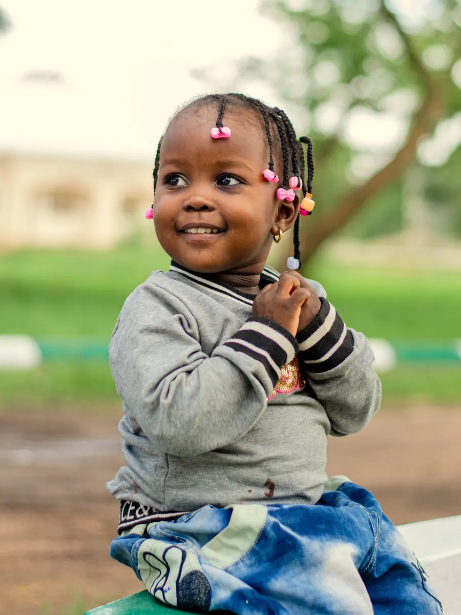 A smiling toddler sitting outdoors at Aquila Nidus