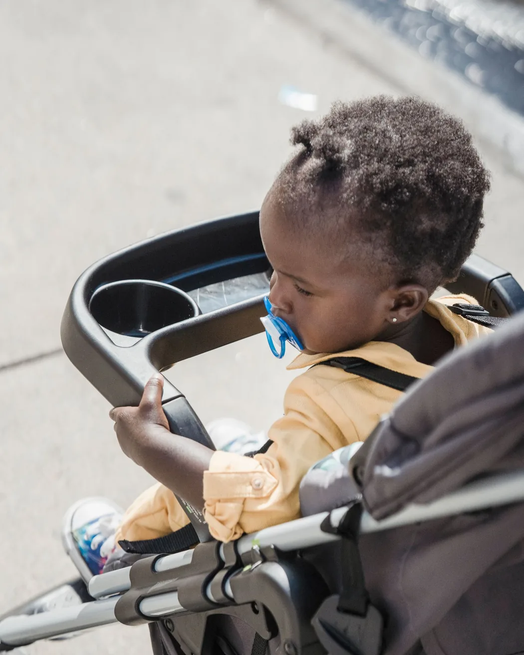 A toddler looking out from their stroller