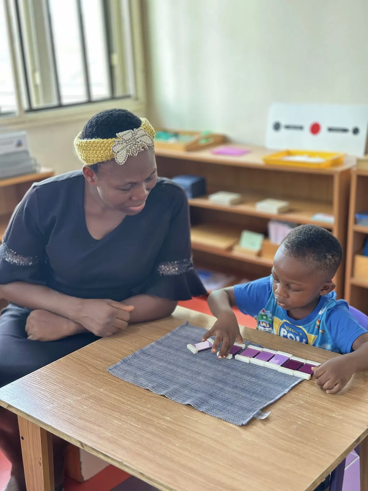 An AMI-certified guide working closely with a child at Aquila Nidus