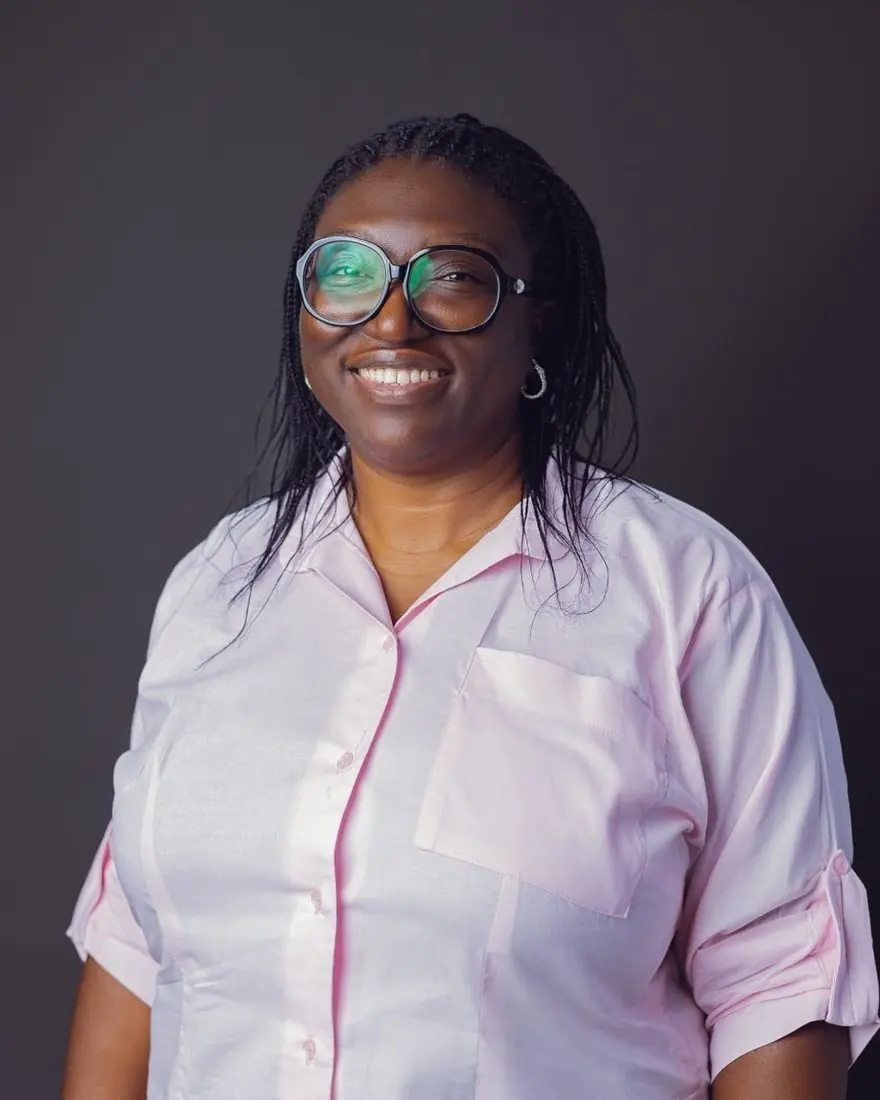 Mrs Ajoke David, founder of Aquila Nidus Montessori School, smiling in a pink shirt
